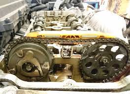Exposed engine timing chain and camshaft gears during repair, showing internal mechanical components and chain alignment.