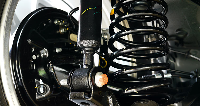 Detailed view of a vehicle suspension system showing a coil spring, shock absorber, and control arm assembly.